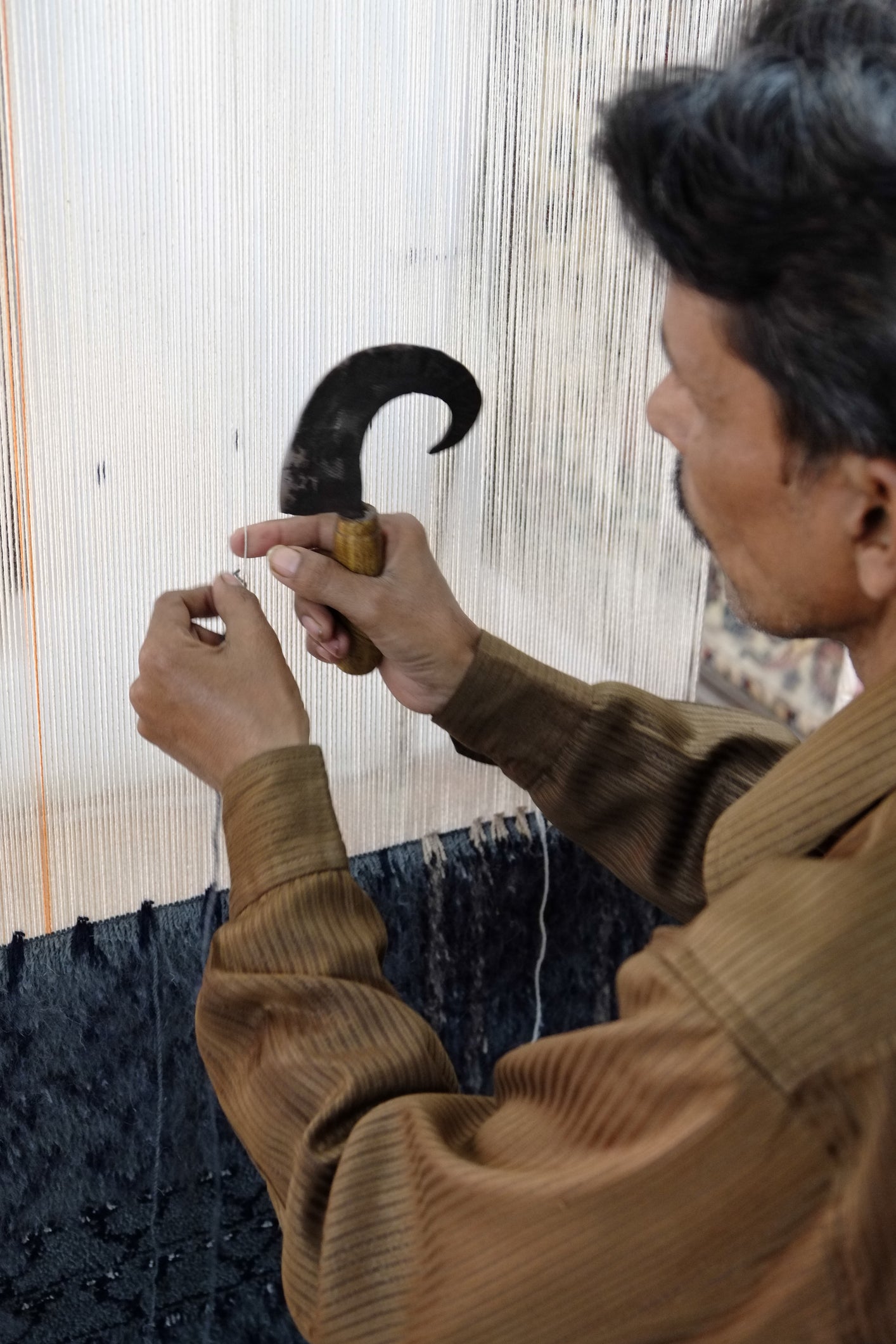 man knotting a rug by hand